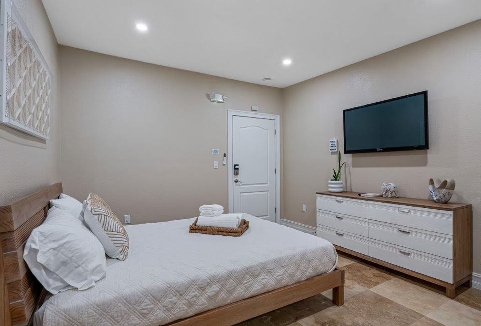 Cama queen con televisor y cómoda